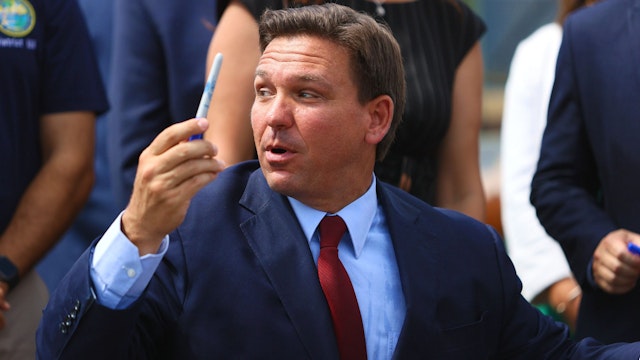 MIAMI, FLORIDA - JUNE 07: Florida Gov. Ron DeSantis gives away a pen after holding a bill signing ceremony at the Florida National Guard Robert A. Ballard Armory on June 07, 2021 in Miami, Florida. The governor signed the bills to combat foreign influence and corporate espionage in Florida from governments like China.