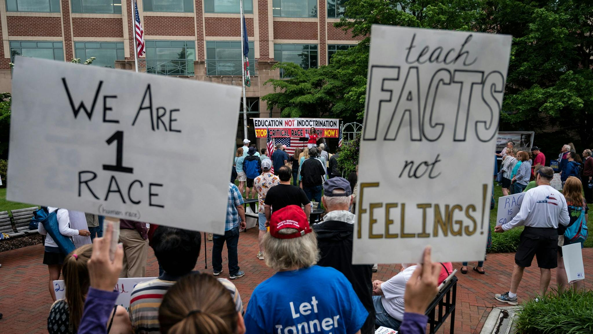 Teach Facts Not Feelings People hold up signs during a rally against "critical race theory" (CRT) being taught in schools at the Loudoun County Government center in Leesburg, Virginia on June 12, 2021. - "Are you ready to take back our schools?" Republican activist Patti Menders shouted at a rally opposing anti-racism teaching that critics like her say trains white children to see themselves as "oppressors." "Yes!", answered in unison the hundreds of demonstrators gathered this weekend near Washington to fight against "critical race theory," the latest battleground of America's ongoing culture wars. The term "critical race theory" defines a strand of thought that appeared in American law schools in the late 1970s and which looks at racism as a system, enabled by laws and institutions, rather than at the level of individual prejudices. But critics use it as a catch-all phrase that attacks teachers' efforts to confront dark episodes in American history, including slavery and segregation, as well as to tackle racist stereotypes. (Photo by ANDREW CABALLERO-REYNOLDS / AFP)
