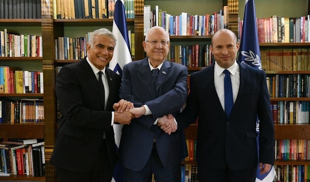 JERUSALEM - JUNE 14: Israeli President Reuven Rivlin (C) shake hands with Prime Minister Naftali Bennett (R) and Alternate Israeli Prime Minister and Foreign Minister Yair Lapid (L) after the Knesset (Israelâs parliament) gave confidence on Sunday to the new coalition government, at the President's Residence in Jerusalem on June 14, 2021. (Photo by GPO/Anadolu Agency via Getty Images)
