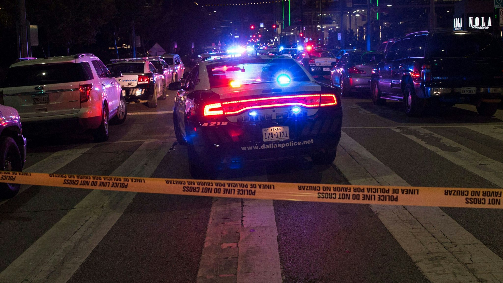 TOPSHOT - Police cars sit on Main Street in Dallas following the sniper shooting during a protest on July 7, 2016. - A fourth police officer was killed and two suspected snipers were in custody after a protest late Thursday against police brutality in Dallas, authorities said. One suspect had turned himself in and another who was in a shootout with SWAT officers was also in custody, the Dallas Police Department tweeted.