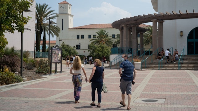 Students and parents walk on campus during move-in day at San Diego State University in San Diego, California, U.S., on Friday, Aug. 21, 2020.