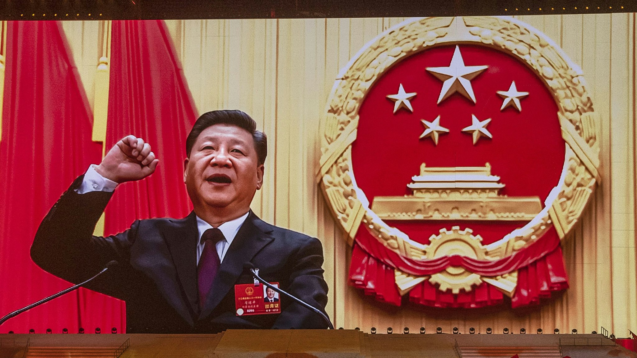 BEIJING, CHINA - JUNE 28: Chinese President and Chairman of the Communist Party Xi Jinping appears on a large screen as performers dance during a mass gala marking the 100th anniversary of the Communist Party on June 28, 2021 at the Olympic Bird's Nest stadium in Beijing, China. China will officially mark the100th anniversary of the founding of the Communist Party on July 1st.