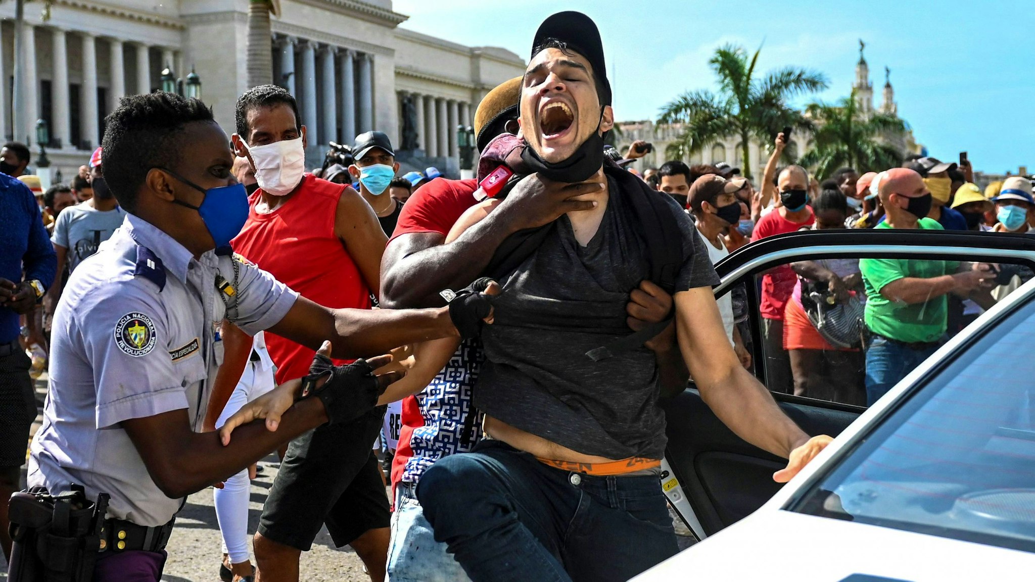 A man is arrested during a demonstration against the government of Cuban President Miguel Diaz-Canel in Havana, on July 11, 2021. - Thousands of Cubans took part in rare protests Sunday against the communist government, marching through a town chanting "Down with the dictatorship" and "We want liberty."