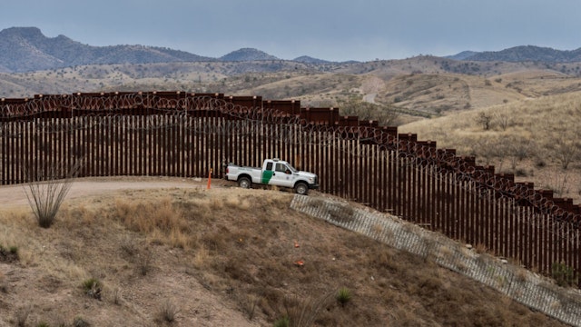 A Border Patrol officer sits inside his car as he guards the US/Mexico border fence, in Nogales, Arizona, on February 9, 2019.