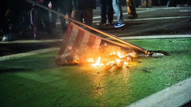 Protesters burn a US flag in Portland, Oregon on November 4, 2020, during a demonstration called by the "Black Lives Matter" movement, a day after the US Presidential Election