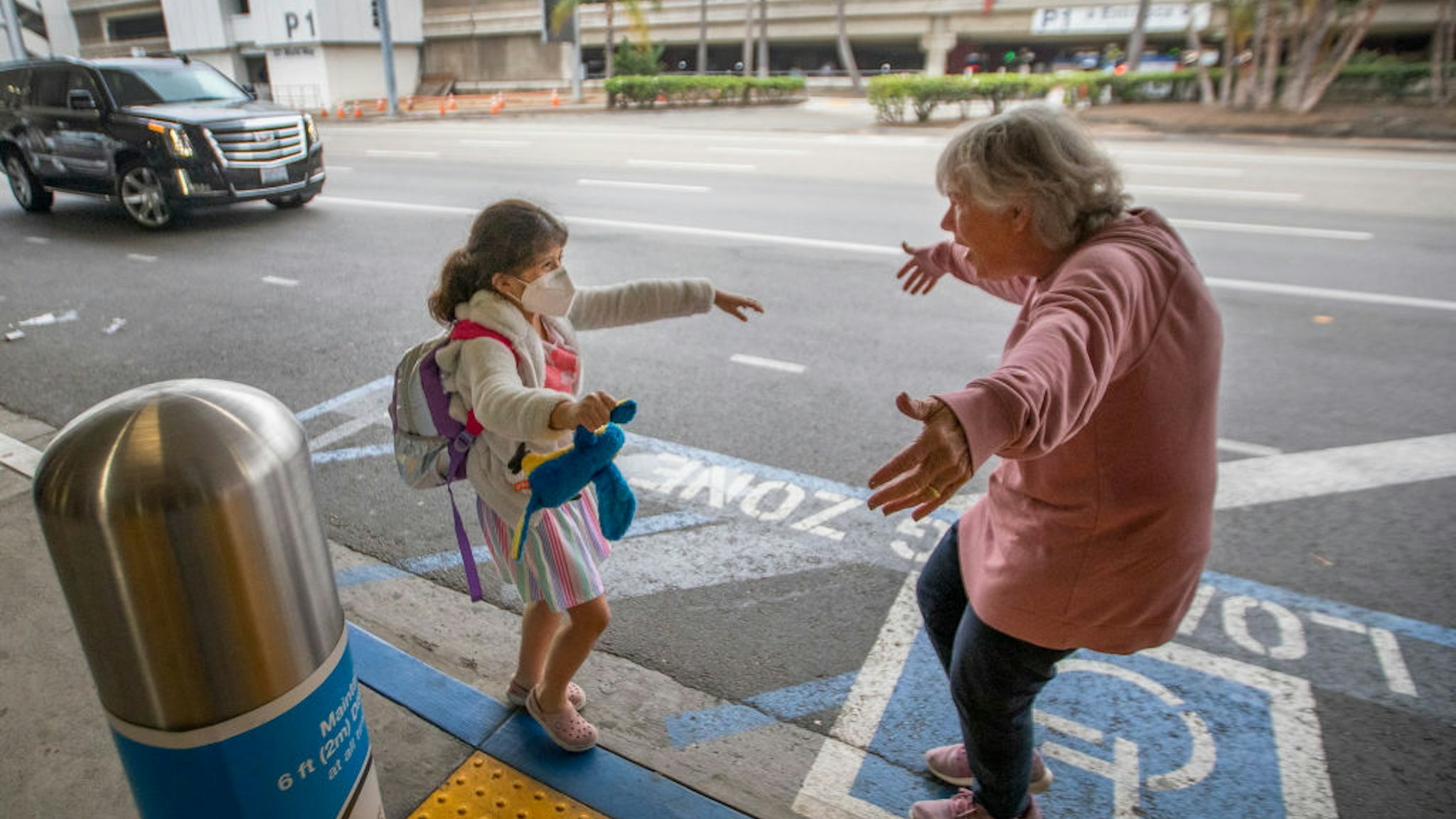 LOS ANGELES, CA - NOVEMBER 23: Traveler Jacquie Carney, 7, of San Antonio, TX, runs to hug her grandma, Donna Vidrine, of San Clemente, upon arrival at LAX as the Thanksgiving holiday getaway period gets underway on Monday, Nov. 23, 2020 in Los Angeles, CA. Millions of Americans are carrying on with their travel plans ahead of Thanksgiving weekend despite the CDC's urgent warnings to stay home as the number of daily cases and hospitalizations in the country continue to hit record highs. Confirmed cases in the U.S. for the disease topped 12 million on Saturday as more than 193,000 new infections were recorded in the US on Friday. This broke the previous record for the largest single-day spike on Thursday - and over 82,000 patients are now hospitalized across the country. (Allen J. Schaben / Los Angeles Times via Getty Images)