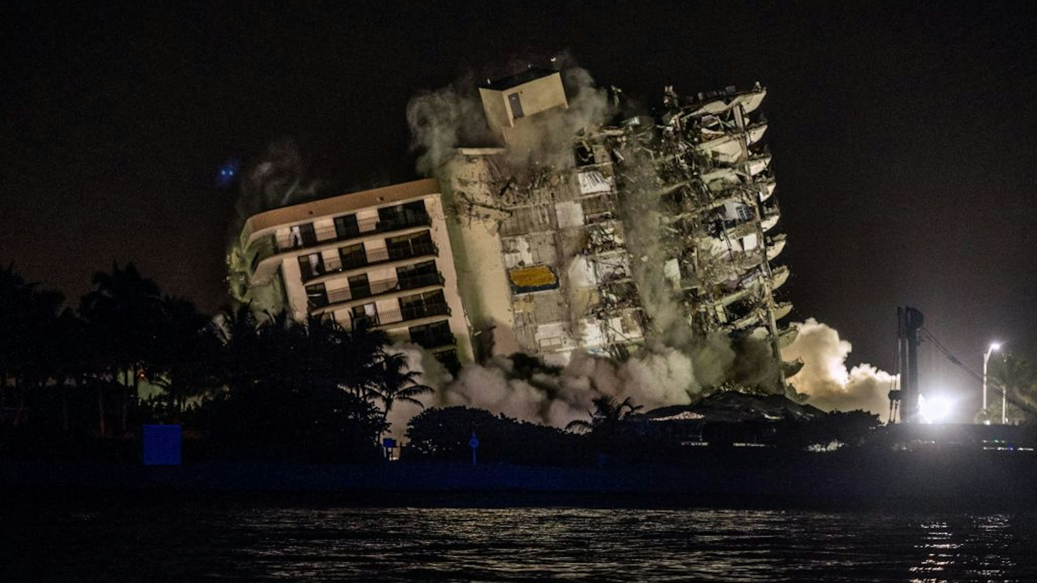 The rest of the Champlain South tower is seen being demolished in Surfside, Florida, north of Miami Beach, late on July 4, 2021. - A controlled explosion brought down the unstable remains of the collapsed apartment block in Florida late on July 4 ahead of a threatening tropical storm as rescuers prepare to resume searching for victims. (Photo by Giorgio VIERA / AFP) (Photo by GIORGIO VIERA/AFP via Getty Images)