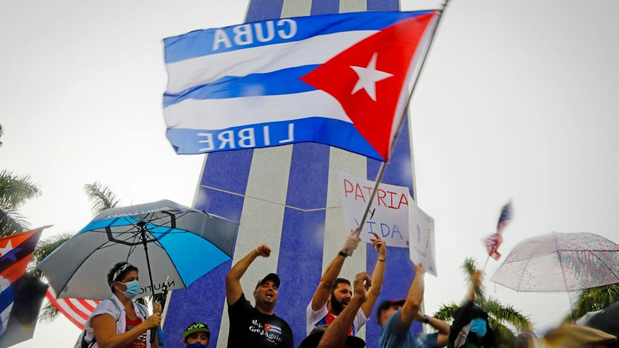 People demonstrate waving Cuban flags during a protest against the Cuban government at Tamiami Park in Miami, on July 13, 2021. - Washington warned Haitians and Cubans against trying to flee to the United States as they endure domestic unrest, saying the trip is dangerous and they would be repatriated. (Photo by Eva Marie UZCATEGUI / AFP) (Photo by EVA MARIE UZCATEGUI/AFP via Getty Images)