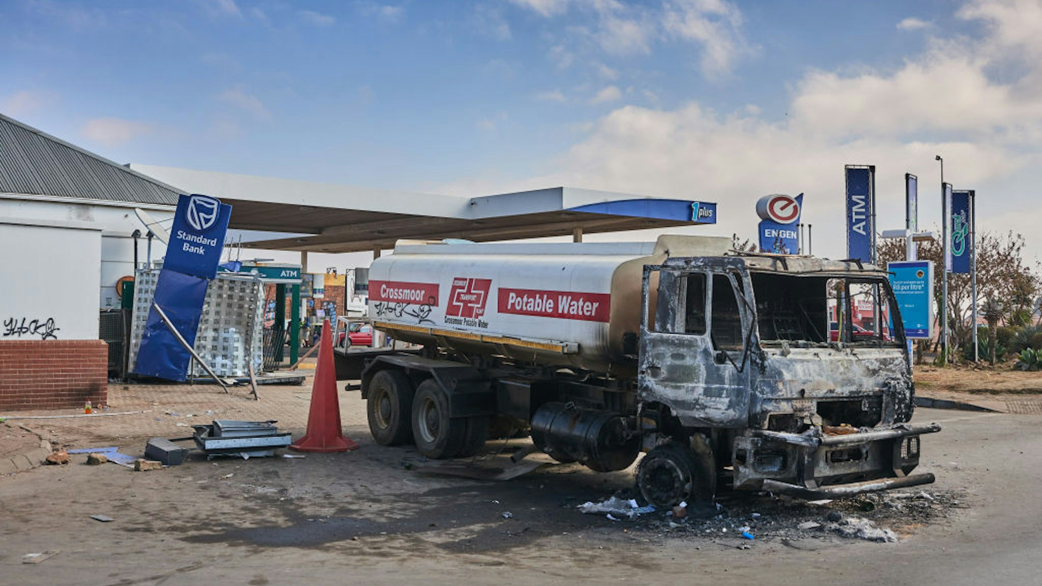A burnt out water tanker by a damaged Engen Ltd. gas station following rioting in the Soweto district of Johannesburg, South Africa, on Thursday, July 15, 2021. Marauding mobs have ransacked hundreds of businesses and destroyed telecommunications towers and other infrastructure, while transport networks and a program to vaccinate people against the coronavirus have been disrupted. Photographer: Waldo Swiegers/Bloomberg via Getty Images