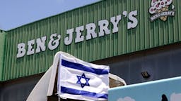 ISRAEL-PALESTINIANS-CONFLICT-FOOD An Israeli flag is set atop a delivery truck outside US ice-cream maker Ben & Jerry's factory in Be'er Tuvia, on July 21, 2021. - Ben & Jerry's announced that it will stop selling ice cream in the Israel-occupied Palestinian territories since it was "inconsistent with our values", although it said it planned to keep selling its products in Israel. The West Bank and East Jerusalem have been under Israeli control since 1967. Roughly 475,000 Jewish settlers live in the West Bank, in communities widely regarded as illegal under international law, alongside some 2.8 million Palestinians. (Photo by Emmanuel DUNAND / AFP) (Photo by EMMANUEL DUNAND/AFP via Getty Images)