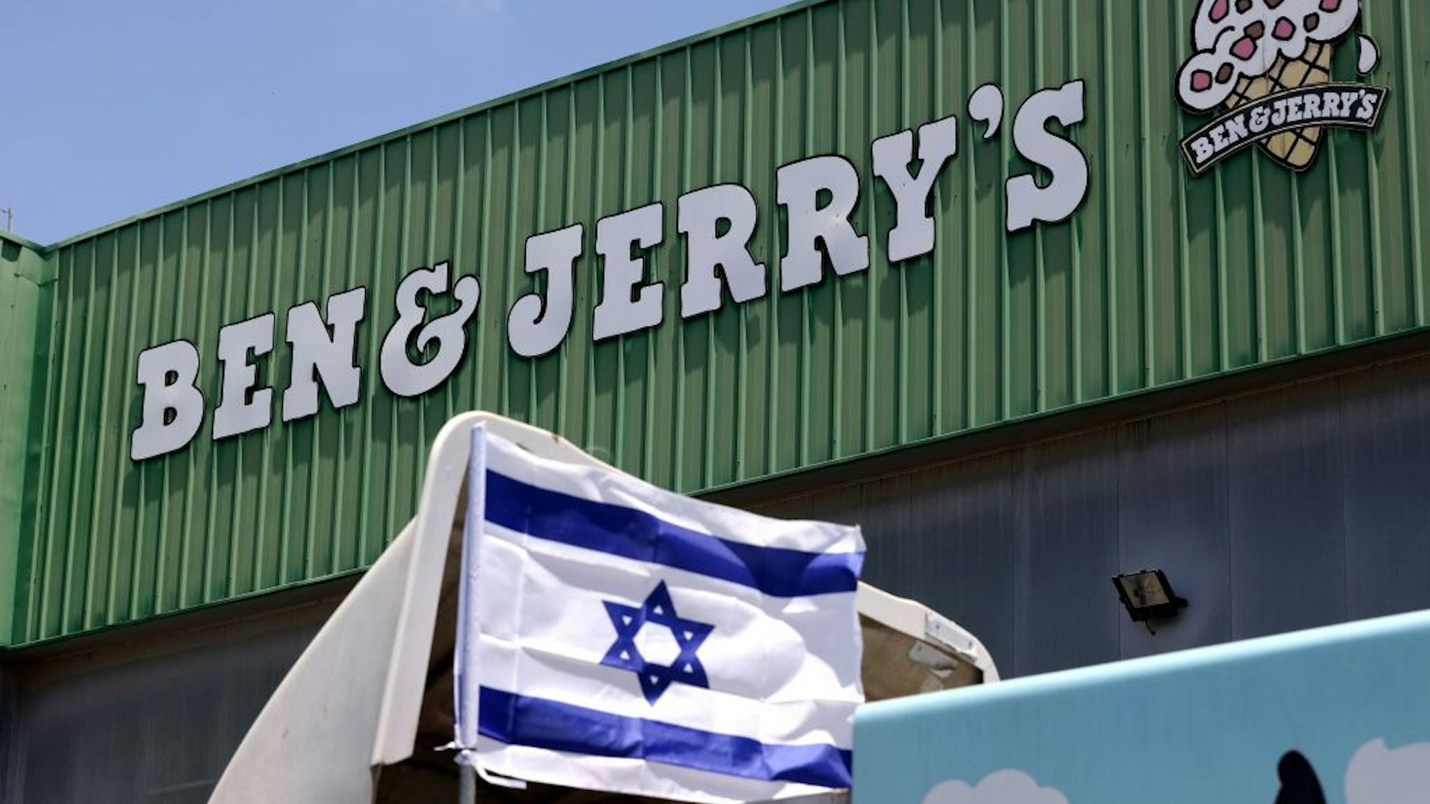 An Israeli flag is set atop a delivery truck outside US ice-cream maker Ben &amp; Jerry's factory in Be'er Tuvia, on July 21, 2021. - Ben &amp; Jerry's announced that it will stop selling ice cream in the Israel-occupied Palestinian territories since it was "inconsistent with our values", although it said it planned to keep selling its products in Israel. The West Bank and East Jerusalem have been under Israeli control since 1967. Roughly 475,000 Jewish settlers live in the West Bank, in communities widely regarded as illegal under international law, alongside some 2.8 million Palestinians. (Photo by Emmanuel DUNAND / AFP) (Photo by EMMANUEL DUNAND/AFP via Getty Images)