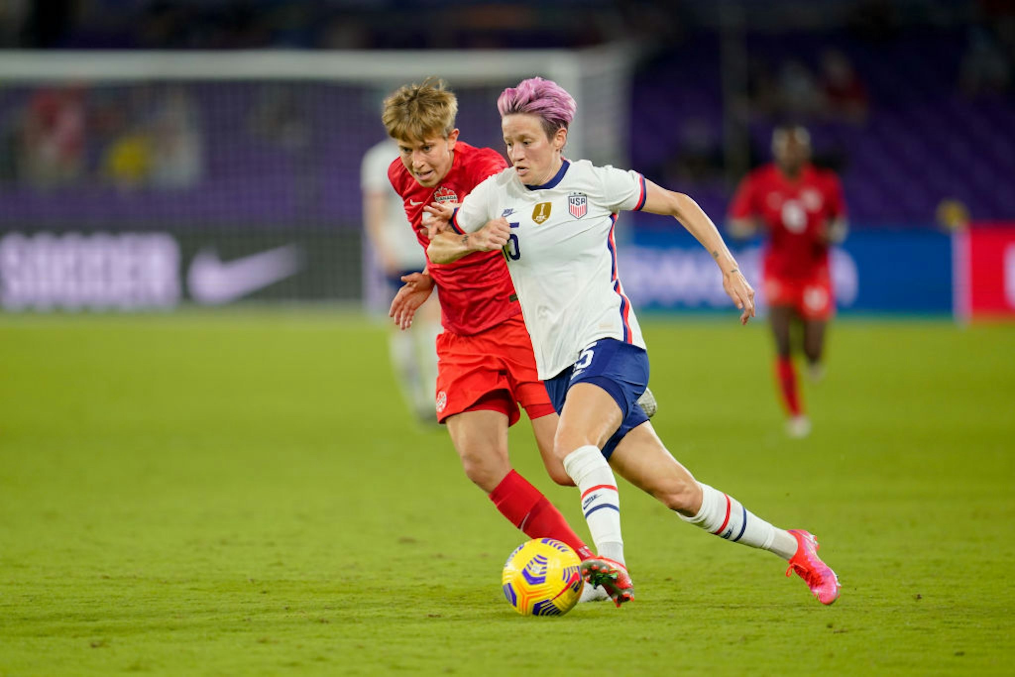 Megan Rapinoe #15 of the United States moves past Quinn #5 of Canada during a game between Canada and USWNT at Exploria Stadium on February 18, 2021 in Orlando City, Florida.