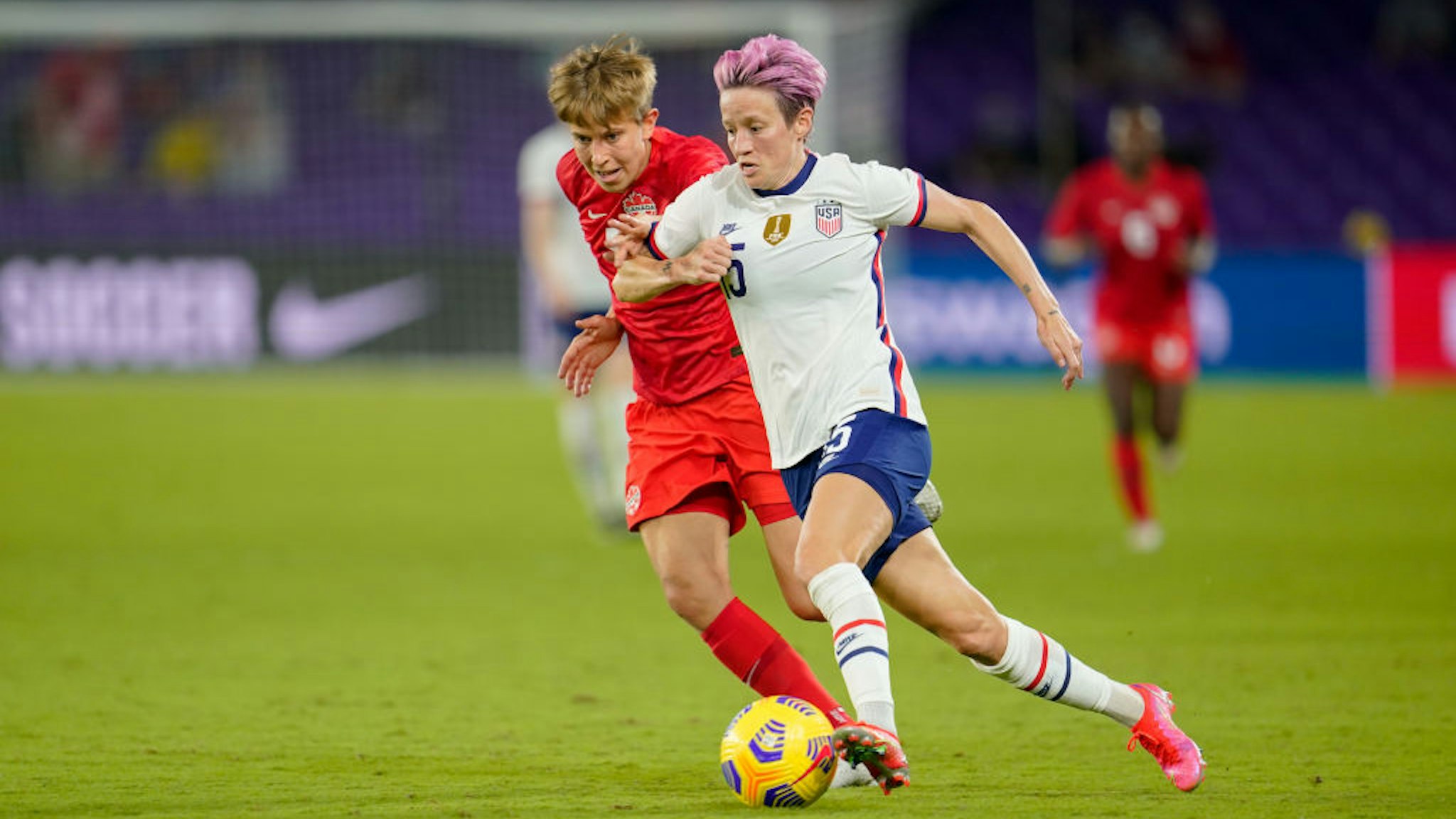 Megan Rapinoe #15 of the United States moves past Quinn #5 of Canada during a game between Canada and USWNT at Exploria Stadium on February 18, 2021 in Orlando City, Florida.