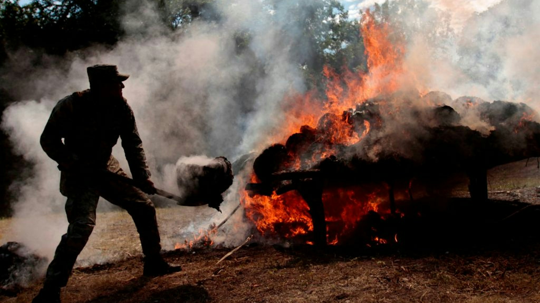 A Mexican Army soldier burns about 945 kilograms of marijuana at the headquarters of IX Militar Region in Acapulco, Guererro state, on December 8, 2011. The drug was seized to alleged members of drugs cartels who operate in the touristic port city of Acapulco. AFP PHOTO/Pedro PARDO (Photo by Pedro PARDO / AFP) (Photo by PEDRO PARDO/AFP via Getty Images)