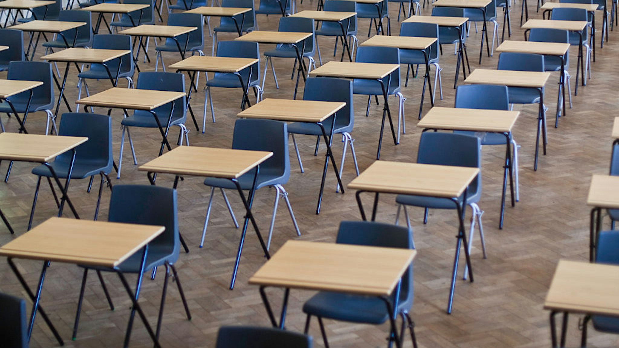 Desks and chairs set out for exams in a school hall in the United Kigdom. (Photo by In Pictures Ltd./Corbis via Getty Images)