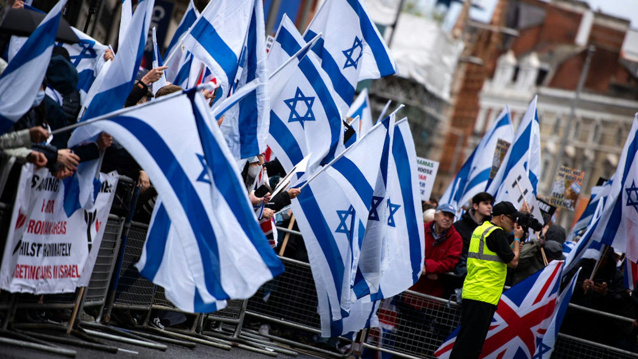 LONDON, UNITED KINGDOM - 2021/05/23: Protesters wave Israeli flags at the Israeli Embassy on High Street Kensington during the demonstration. A pro Israeli demonstration held around Embassy of Israel in solidarity with Israel after cease-fire agreement between Israel and Hamas on May 21, 2021 in Gaza City.