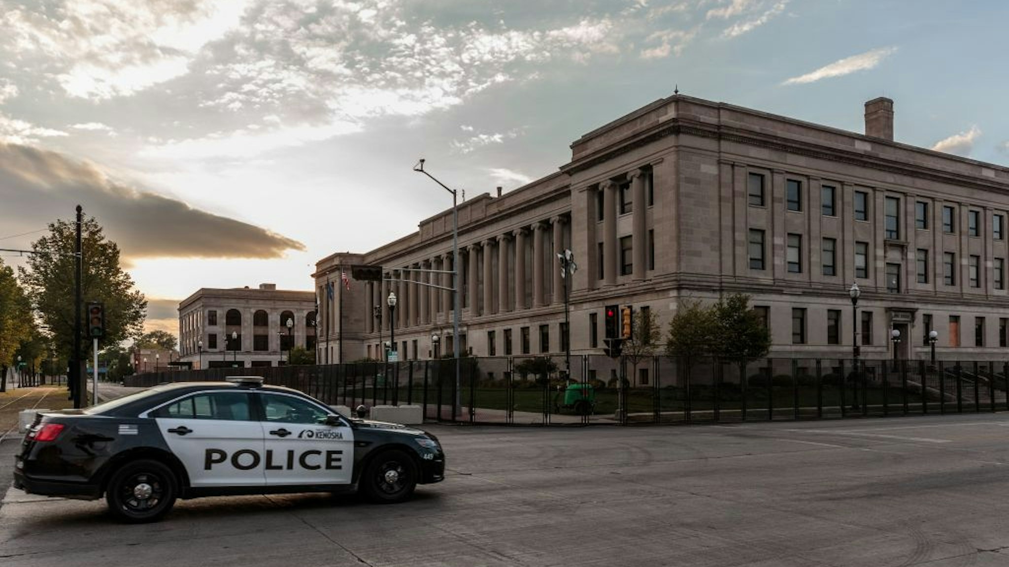 A Kenosha Police car drives past the Kenosha Courthouse surrounded by surrounded by temporary security gates during curfew in Kenosha, Wisconsin on August 31, 2020, following the shooting of Jacob Blake by police. - Donald Trump has no plans to meet with relatives of Jacob Blake, a black man who was shot by police, when the president visits the Wisconsin city where the shooting sparked violent demonstrations, the White House said on August 31. Trump travels to Kenosha, Wisconsin on September 1, defying Democratic leaders there who have reportedly urged him not to visit the city in the wake of the shooting. (Photo by Kerem Yucel / AFP) (Photo by KEREM YUCEL/AFP via Getty Images)