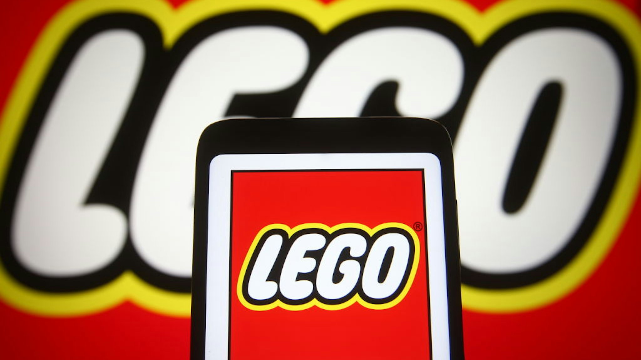 UKRAINE - 2021/04/02: In this photo illustration a Lego logo is seen on a smartphone and a pc screen.