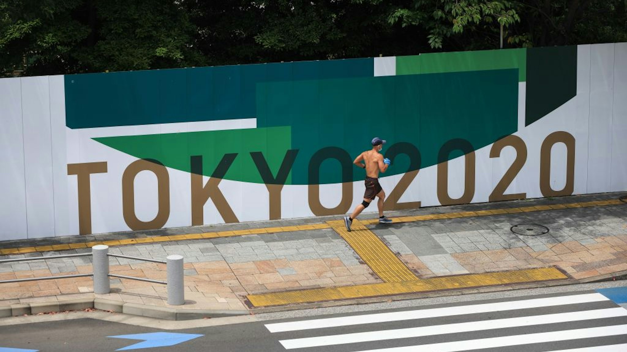 ARIAKE, TOKYO, JAPAN - 2021/06/28: A jogger runs in Odaiba Marine Park in Ariake, Tokyo. 25 Days before the opening ceremony of the Tokyo 2020 Summer Olympic Games many sporting venues and fan zones are still under construction.