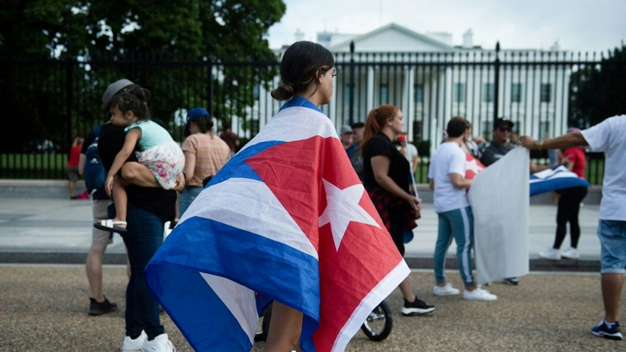 People supporting protests in Cuba gather on Pennsylvania Avenue outside the White House grounds July 13, 2021, in Washington, DC. - Washington warned Haitians and Cubans against trying to flee to the United States as they endure domestic unrest, saying the trip is dangerous and they would be repatriated. (Photo by Brendan Smialowski / AFP) (Photo by