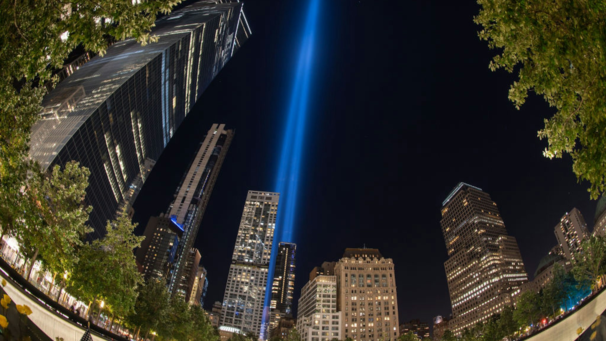 MANHATTAN, NEW YORK, UNITED STATES - 2020/09/11: (EDITORS NOTE: Image taken with fish eye lens) View of Tribute of Light illuminates skies above the south reflecting pool of the National September 11 Memorial and Museum on 19th anniversary of terror attack. The twin lights represent the Twin Towers which were destroyed during terror attack in 2001.
