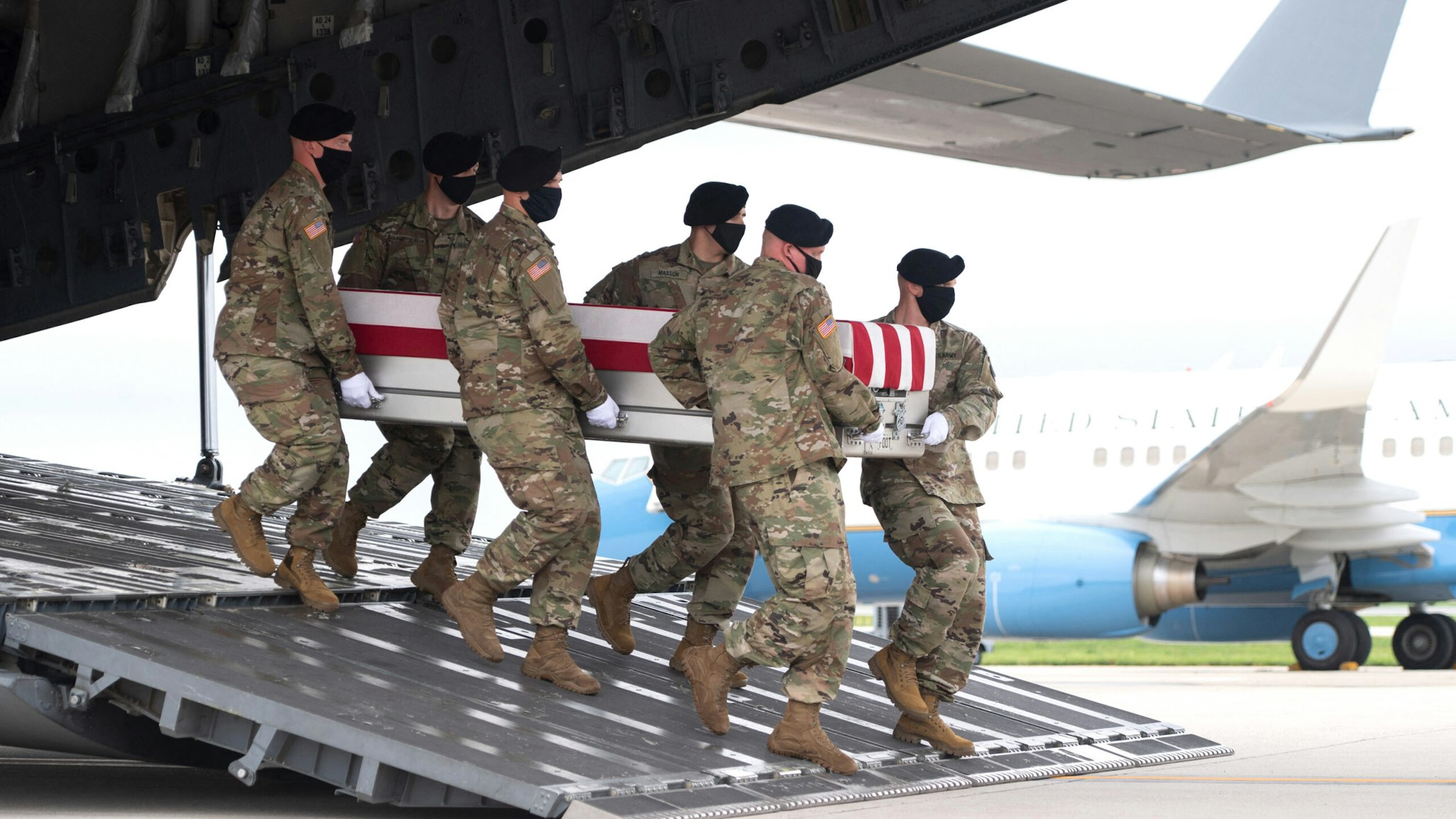 A transfer case with the remains of Army Staff Sgt. Ryan C. Knauss, 23, of Corryton, Tennessee, are carried off of a military aircraft as US President Joe Biden attends the dignified transfer at Dover Air Force Base in Dover, Delaware, August, 29, 2021, one of the 13 members of the US military killed in Afghanistan last week. - President Joe Biden prepared Sunday at a US military base to receive the remains of the 13 American service members killed in an attack in Kabul, a solemn ritual that comes amid fierce criticism of his handling of the Afghanistan crisis. Biden and his wife, Jill, both wearing black and with black face masks, first met far from the cameras with relatives of the dead in a special family center at Dover Air Force Base in Delaware.The base, on the US East Coast about two hours from Washington, is synonymous with the painful return of service members who have fallen in combat.