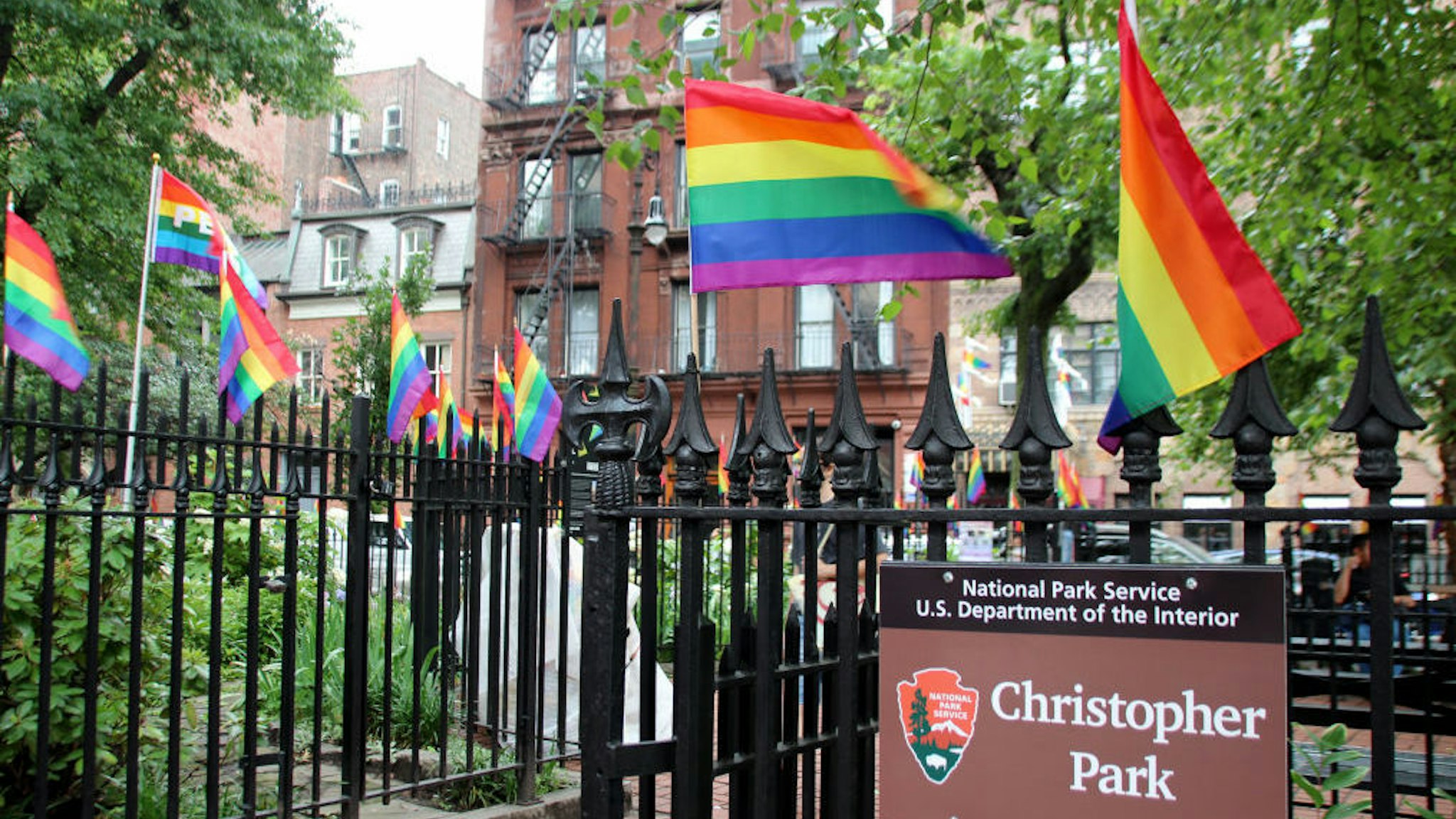 19 June 2019, US, New York: A fence decorated with rainbow flags at Christopher Park opposite the "Stonewall Inn" in the scene district of Greenwich Village. On a warm night on June 28, exactly 50 years ago, about 200 people, including many homosexuals, celebrate in the popular bar "Stonewall Inn" in Christopher Street in Greenwich Village when eight policemen suddenly arrive. It comes to a melee. The riots are the spark that sets an international movement in motion - and the "Stonewall Inn" becomes the nucleus of the protest movement. (to dpa "Metropolis in rainbow colors: New York celebrates 50 years of "Stonewall")