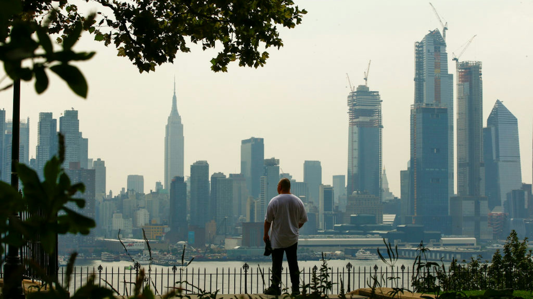 WEEHAWKEN, NJ - AUGUST 17: A man takes a look of the haze over the New York skyline and Empire State Building on August 17, 2018 in Weehawken, New Jersey. Severe thunderstorms and even an isolated tornado could strike New York City on Friday. (Photo by Eduardo Munoz Alvarez/Getty Images