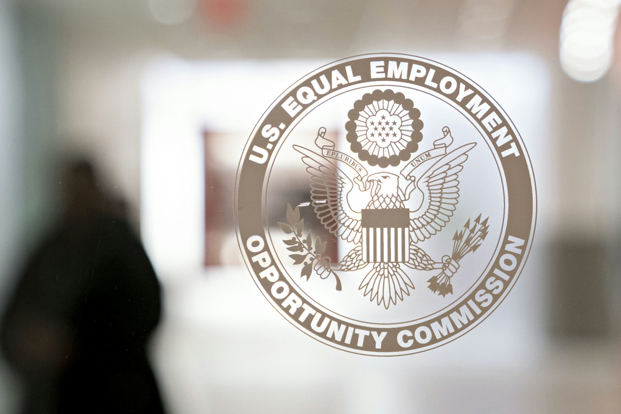 The Equal Employment Opportunity Commission (EEOC) seal is displayed on a window at the headquarters in Washington, D.C., U.S., on Tuesday, Feb. 18, 2020. The Trump administration wants to cut fiscal year 2021 spending on the Labor Department, National Labor Relations Board, and EEOC, reviving previous belt-tightening bids that have not been approved by Congress. Photographer: