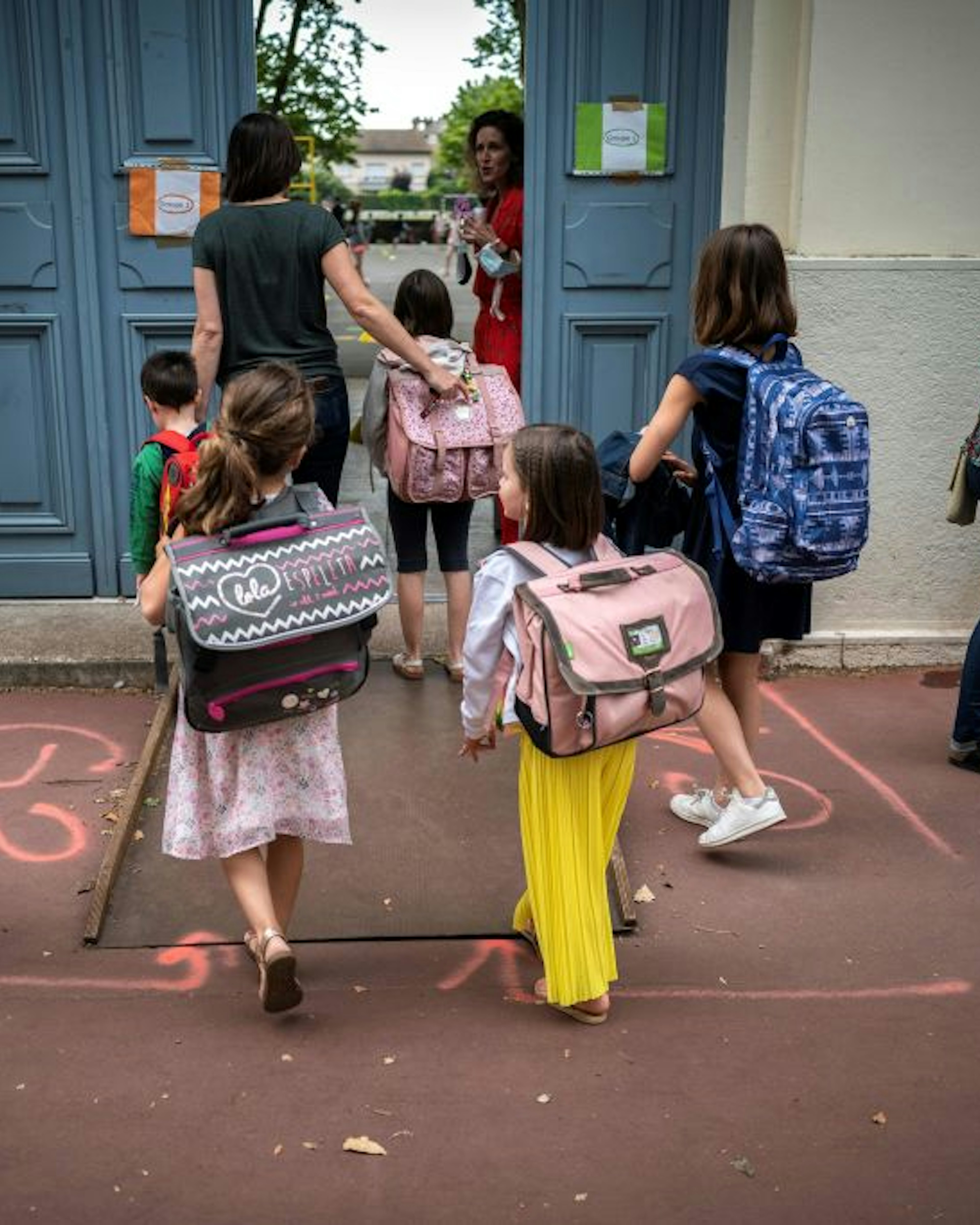 TOPSHOT - Parents and children arrive at the Jules Julien elementary school in Toulouse, southern France, on June 22, 2020 following the reopening of schools as France eases lockdown measures taken to curb the spread of the COVID-19 (the novel coronavirus). (Photo by Lionel BONAVENTURE / AFP) (Photo by LIONEL BONAVENTURE/AFP via Getty Images)