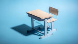 Empty school desk on a blue background. Conceptual.