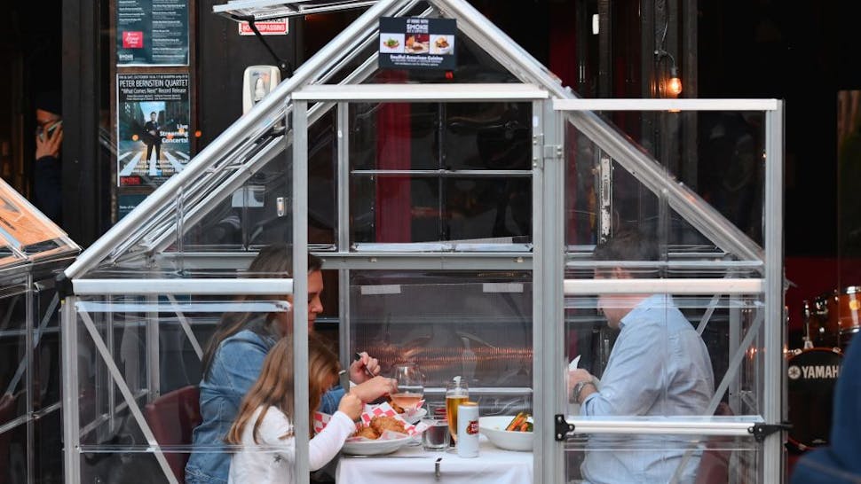 nyc restaurant TOPSHOT - People dine in plastic tents for social distancing at a restaurant in Manhattan on October 15, 2020 in New York City, amid the coronavirus pandemic. (Photo by Angela Weiss / AFP) (Photo by ANGELA WEISS/AFP via Getty Images)