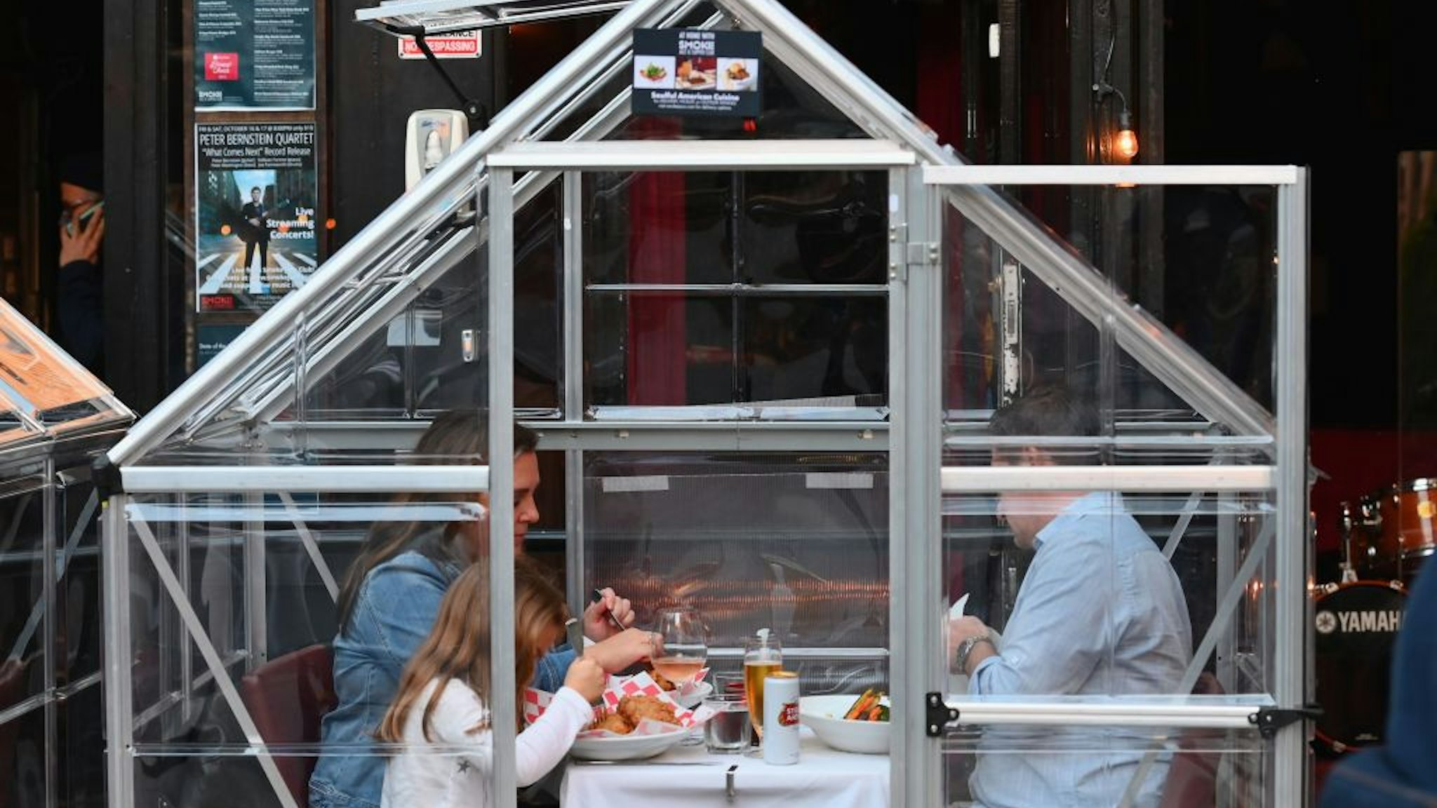 TOPSHOT - People dine in plastic tents for social distancing at a restaurant in Manhattan on October 15, 2020 in New York City, amid the coronavirus pandemic. (Photo by Angela Weiss / AFP) (Photo by ANGELA WEISS/AFP via Getty Images)