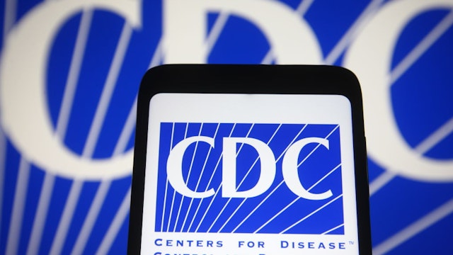 In this photo illustration the Center for Disease Control and Prevention (CDC) logo is seen on a smartphone and a pc screen.