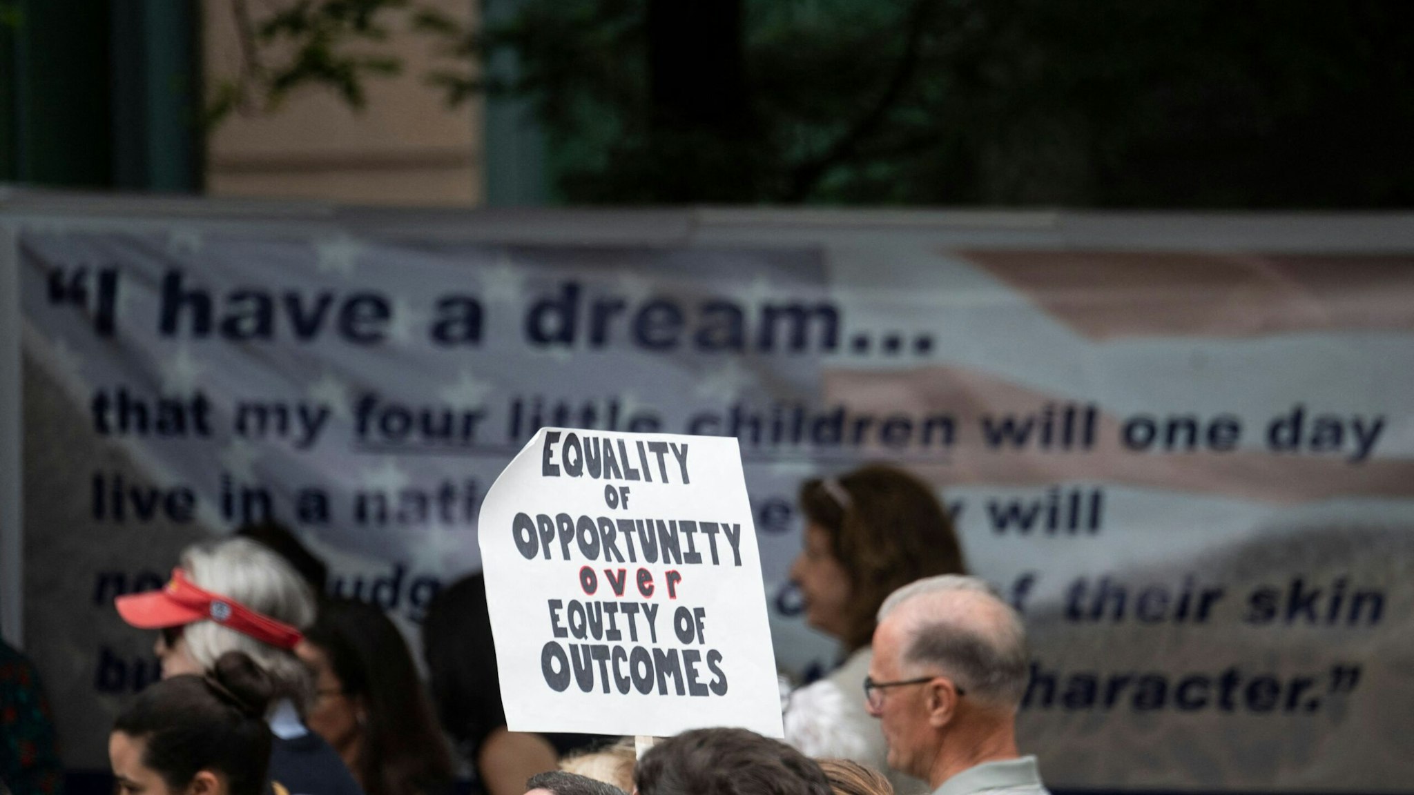 A participant holds up a sign during a rally against "critical race theory" (CRT) being taught in schools at the Loudoun County Government center in Leesburg, Virginia on June 12, 2021. - "Are you ready to take back our schools?" Republican activist Patti Menders shouted at a rally opposing anti-racism teaching that critics like her say trains white children to see themselves as "oppressors." "Yes!", answered in unison the hundreds of demonstrators gathered this weekend near Washington to fight against "critical race theory," the latest battleground of America's ongoing culture wars. The term "critical race theory" defines a strand of thought that appeared in American law schools in the late 1970s and which looks at racism as a system, enabled by laws and institutions, rather than at the level of individual prejudices. But critics use it as a catch-all phrase that attacks teachers' efforts to confront dark episodes in American history, including slavery and segregation, as well as to tackle racist stereotypes. (Photo by ANDREW CABALLERO-REYNOLDS / AFP) (Photo by ANDREW CABALLERO-REYNOLDS/AFP via Getty Images)