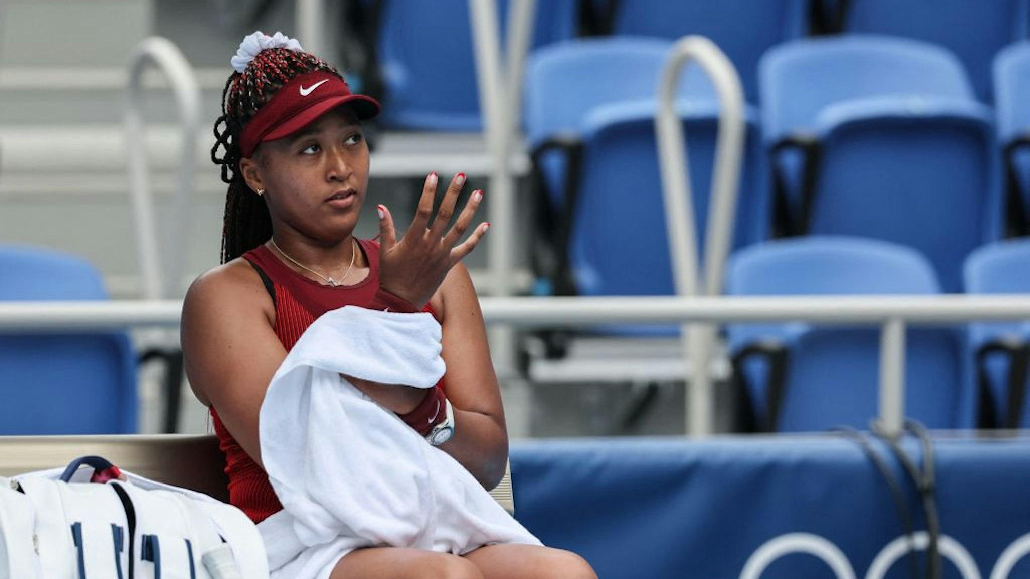 Japan's Naomi Osaka looks on as she pauses between games during their Tokyo 2020 Olympic Games women's singles second round tennis match against Switzerland's Viktorija Golubic at the Ariake Tennis Park in Tokyo on July 26, 2021. (Photo by Giuseppe CACACE / AFP) (Photo by GIUSEPPE CACACE/AFP via Getty Images)