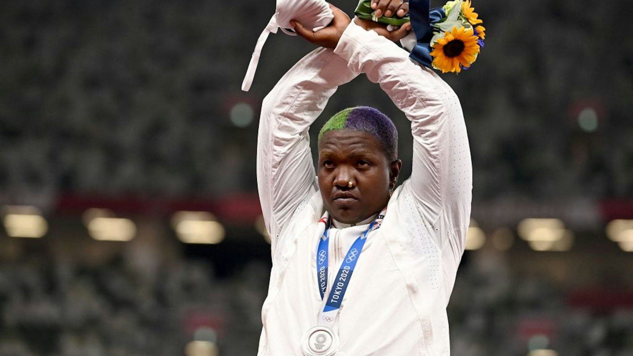 TOPSHOT - Second-placed USA's Raven Saunders gestures on the podium with her silver medal after competing the women's shot put event during the Tokyo 2020 Olympic Games at the Olympic Stadium in Tokyo on August 1, 2021. (Photo by Ina FASSBENDER / AFP) (Photo by INA FASSBENDER/AFP via Getty Images)