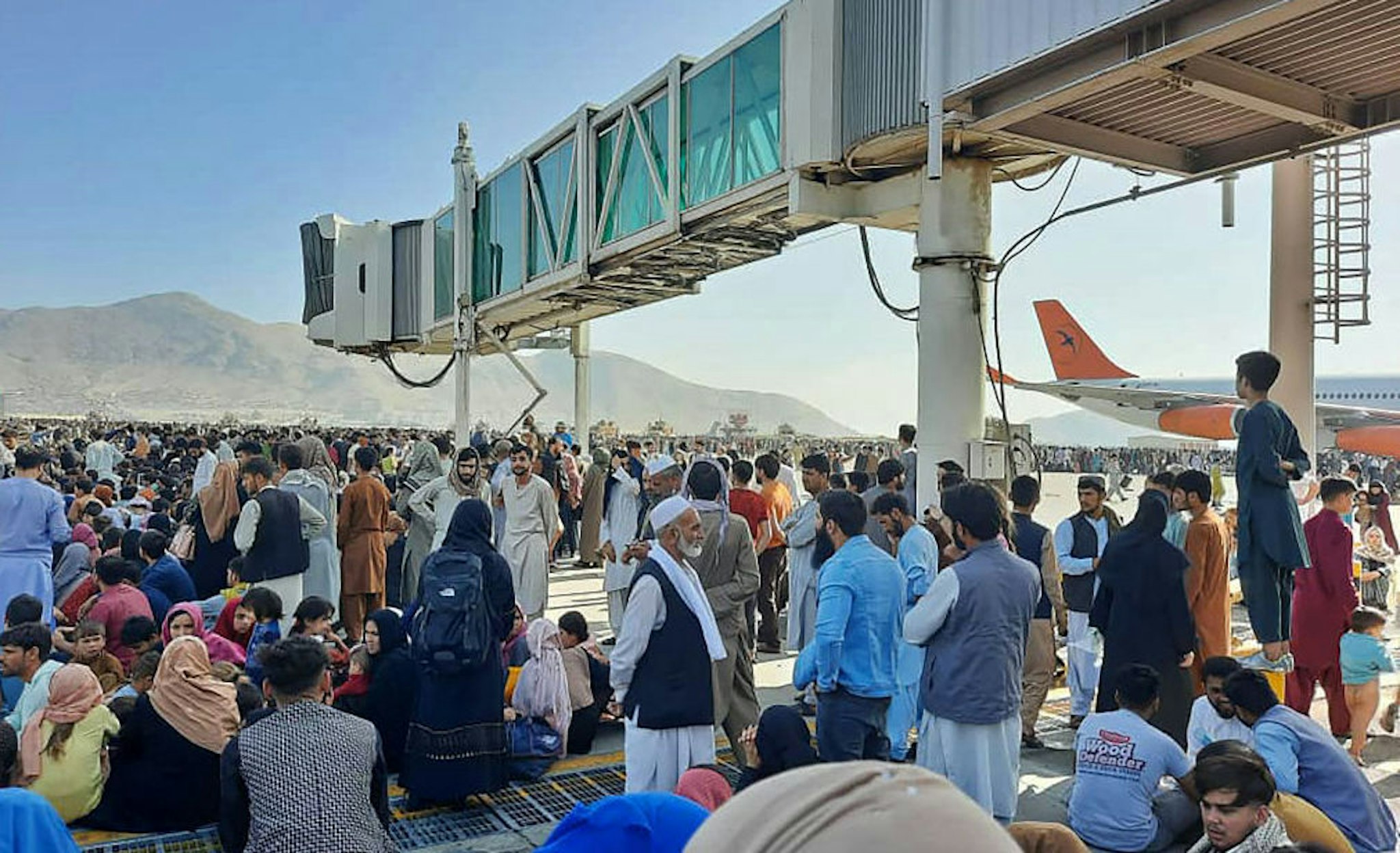 TOPSHOT - Afghans crowd at the tarmac of the Kabul airport on August 16, 2021, to flee the country as the Taliban were in control of Afghanistan after President Ashraf Ghani fled the country and conceded the insurgents had won the 20-year war.