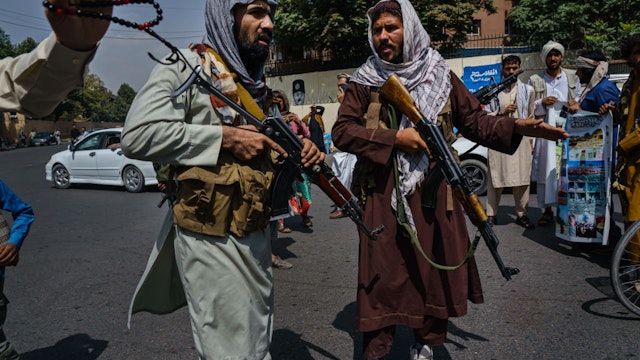 KABUL, AFGHANISTAN -- AUGUST 19, 2021: Taliban fighters mobilize to control a crowd rallying to raise the national flag of the Islamic Republic of Afghanistan during a rally for Independence Day at Pashtunistan Square in Kabul, Afghanistan, Thursday, Aug. 19, 2021.
