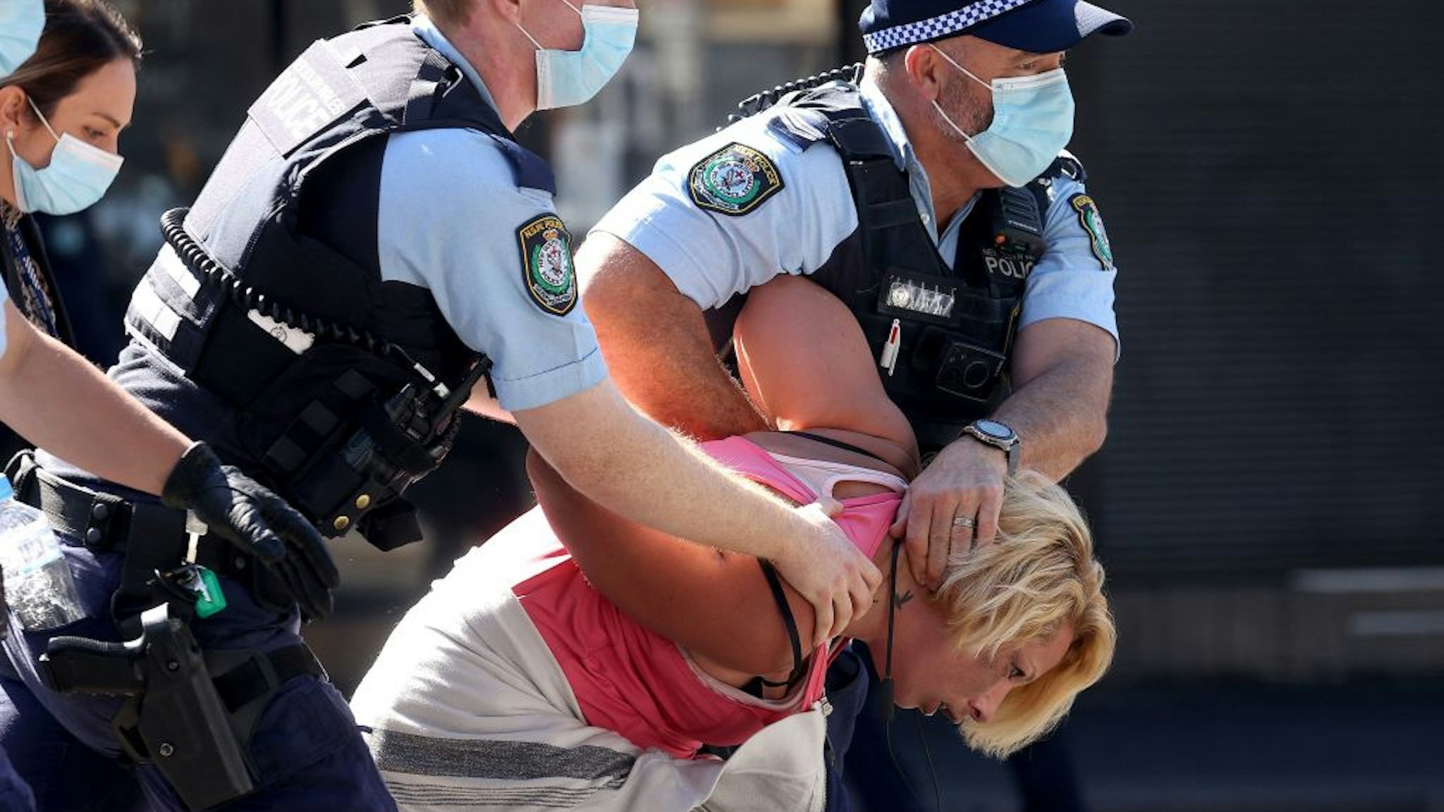 Police officers detain a protestor in Sydney on August 21, 2021, following calls for an anti-lockdown protest rally amid a fast-spreading coronavirus outbreak.