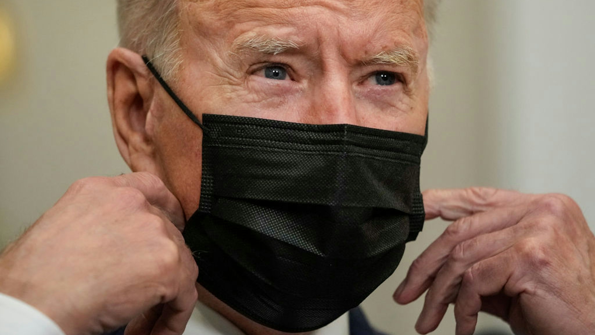 resident Joe Biden removes his mask as he arrives to speak about the situation in Afghanistan in the Roosevelt Room of the White House on August 24, 2021 in Washington, DC.