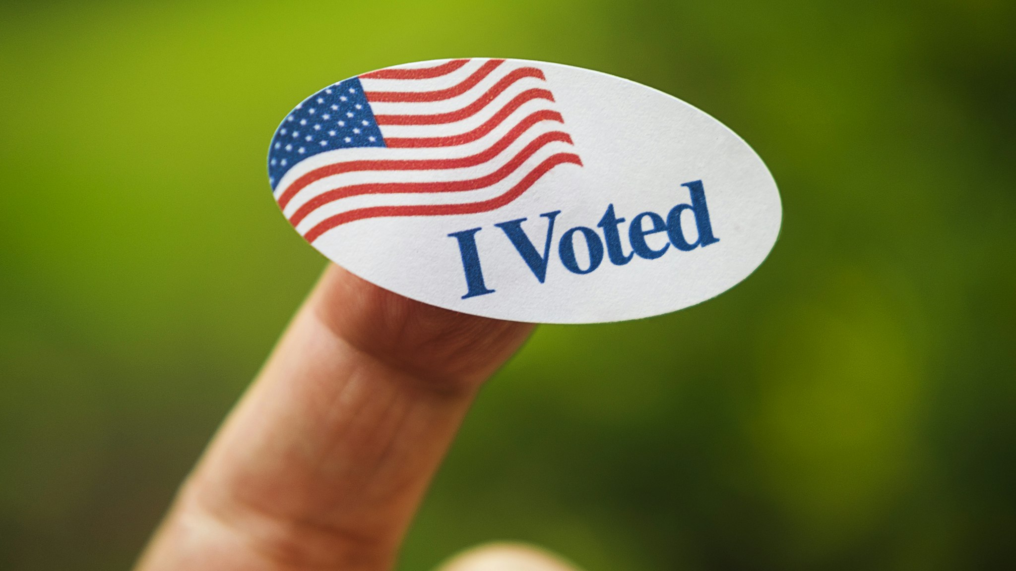 Close-up of I voted sticker on finger - stock photo