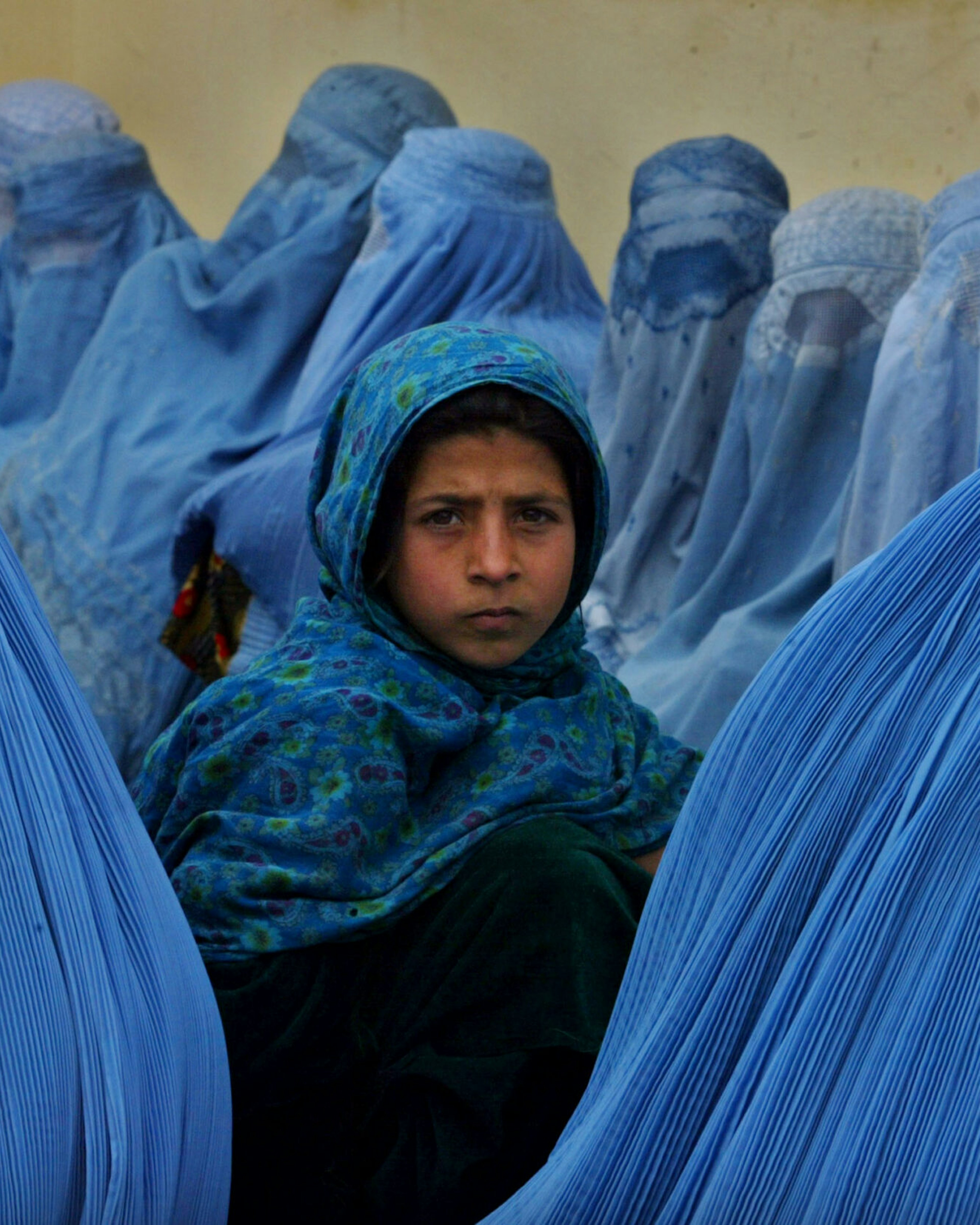 KALAKAN, AFGHANISTAN - FEBRUARY 23: Afghan women wait in line to be treated at the Kalakan health clinic February 23,2003 in Kalakan, Afghanistan. (Photo by Paula Bronstein/Getty Images)