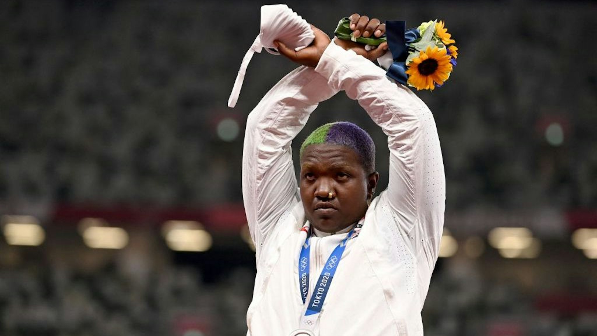 TOPSHOT - Second-placed USA's Raven Saunders gestures on the podium with her silver medal after competing the women's shot put event during the Tokyo 2020 Olympic Games at the Olympic Stadium in Tokyo on August 1, 2021. (Photo by Ina FASSBENDER / AFP) (Photo by INA FASSBENDER/AFP via Getty Images)