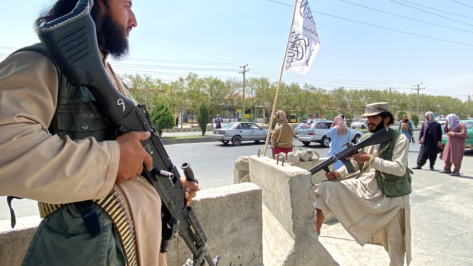 TOPSHOT - Taliban fighters stand guard at an entrance gate outside the Interior Ministry in Kabul on August 17, 2021.