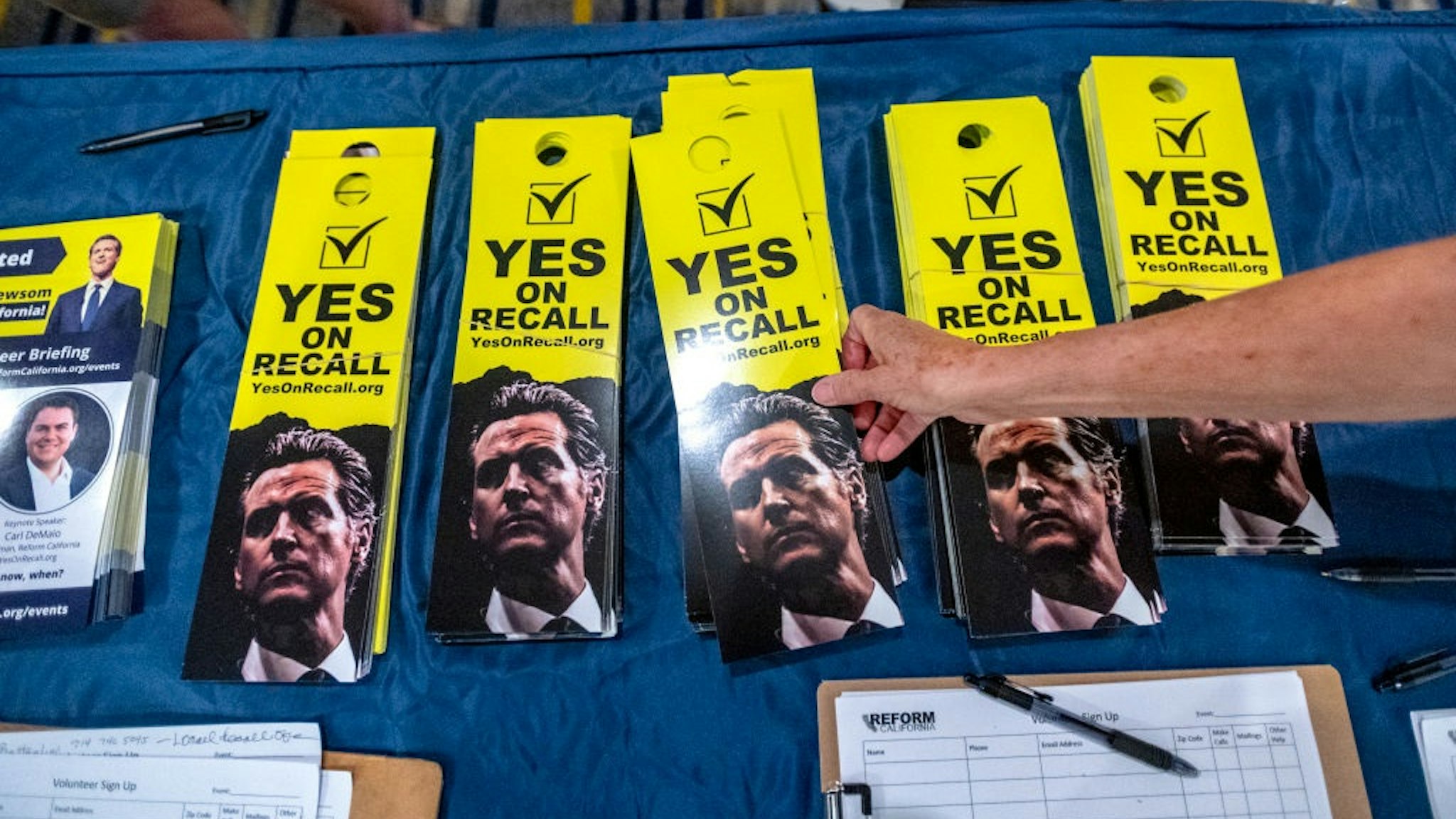 IRVINE, CA - JULY 31: A woman reaches for recall door hangers at a pro-recall rally at an Irvine hotel on Saturday, July 31, 2021, for the upcoming California Gubernatorial Recall Election against Governor Gavin Newsom to be held on September 14, 2021.