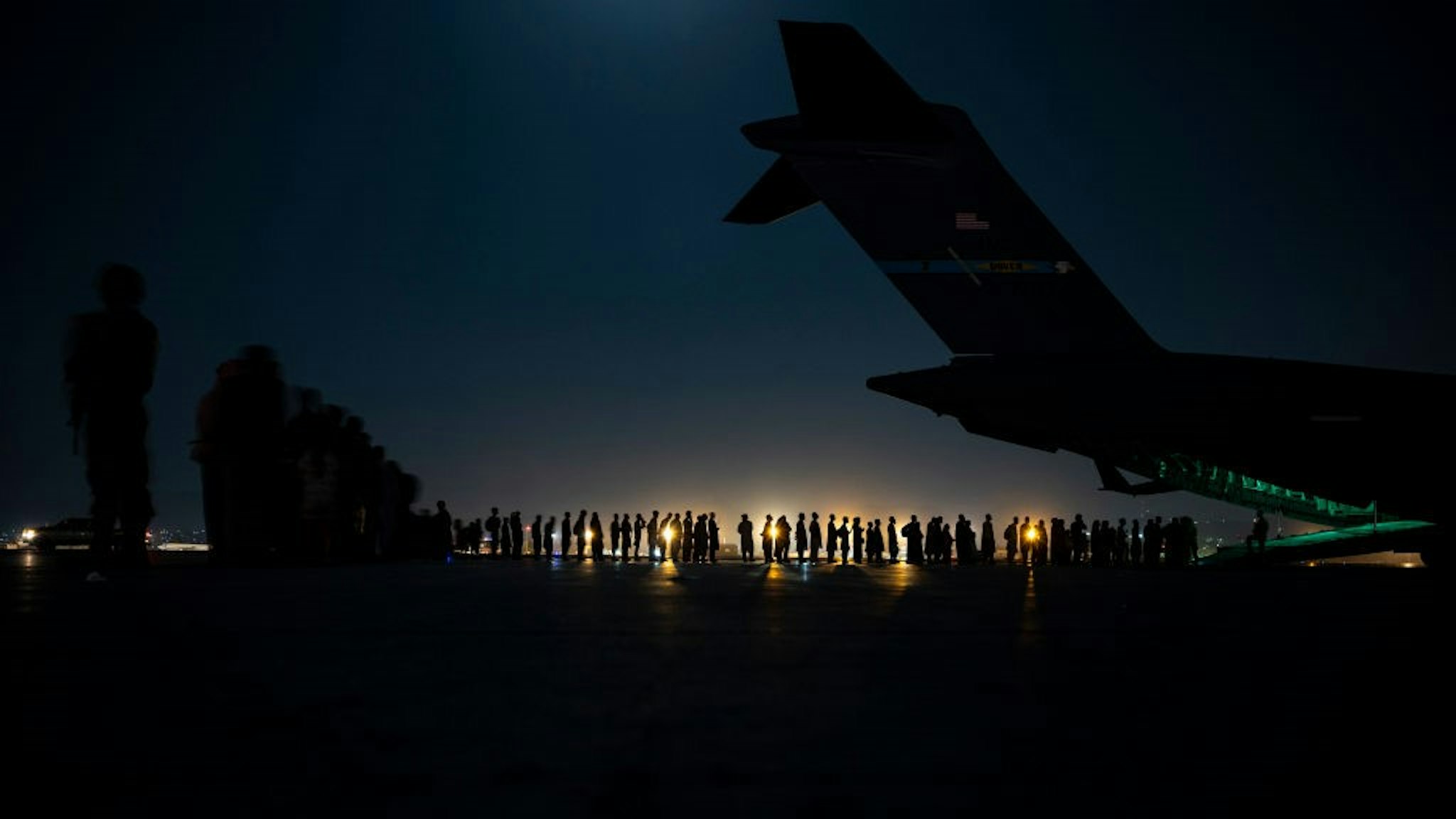 KABUL, AFGHANISTAN - AUGUST 21: In this handout provided by the U.S. Air Force, an air crew prepares to load evacuees aboard a C-17 Globemaster III aircraft in support of the Afghanistan evacuation at Hamid Karzai International Airport on August 21, 2021 in Kabul, Afghanistan. (Photo by