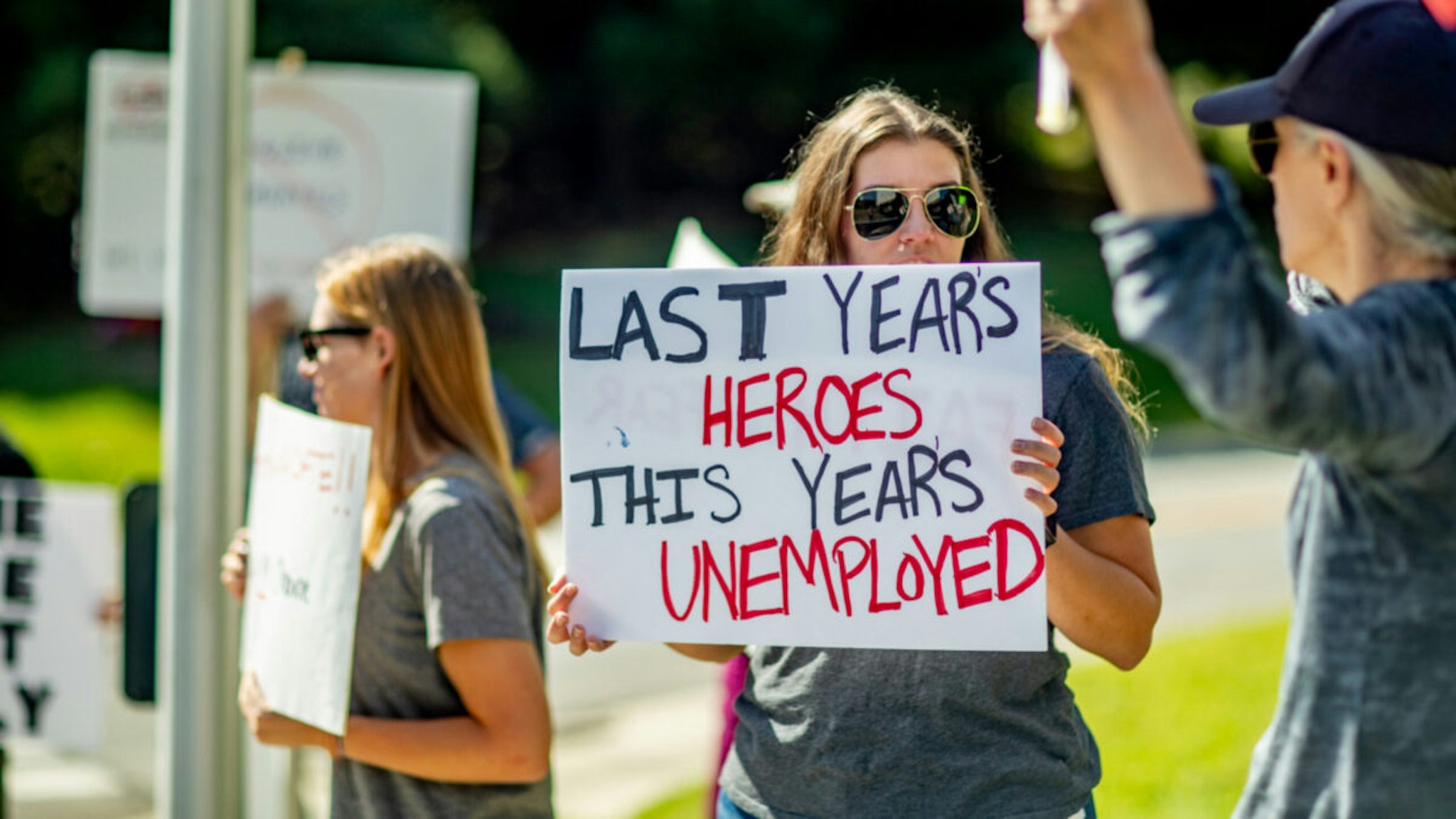 A sign held by a healthcare worker reads "Last Year's Heroes, This Year's Unemployed" at a protest at St. Catherine of Siena Hospital in Smithtown, New York, on Sept. 27, 2021.