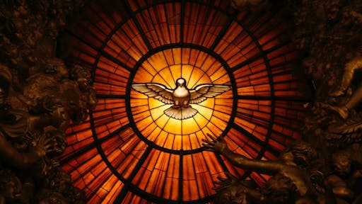 Stained glass dove A detail showing the Holy Spirit from Cathedra Petri by Gian Lorenzo Bernini in St. Peter's Basilica.