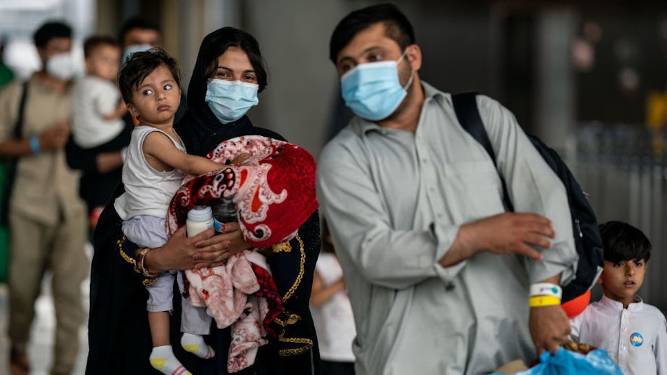 DULLES, VA - AUGUST 31: Evacuees who fled Afghanistan walk through the terminal to board buses that will take them to a processing center, at Dulles International Airport on Tuesday, Aug. 31, 2021. Refugees continue to arrive in the United States, after the US withdrew troops from Afghanistan.